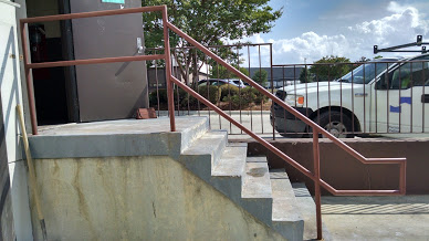 Single line ADA steel railings shown installed. Comforms to the landing stair conture of the concrete stairway